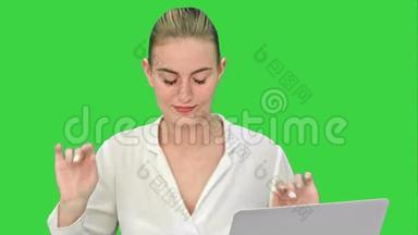 女商人心情愉快，手提电脑坐在<strong>办公</strong>桌上，在绿色屏幕上<strong>接电话</strong>，Chroma